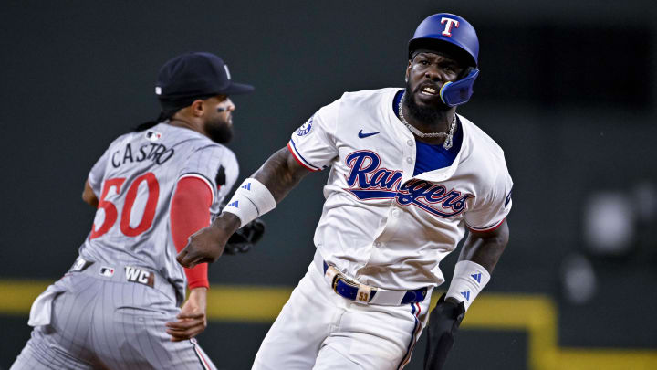 Aug 15, 2024; Arlington, Texas, USA; Texas Rangers right fielder Adolis Garcia (53) runs past Minnesota Twins shortstop Willi Castro (50) during the third inning at Globe Life Field. Mandatory Credit: Jerome Miron-USA TODAY Sports