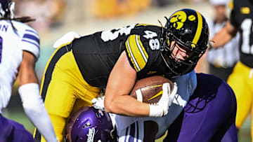 Oct 26, 2024; Iowa City, Iowa, USA; Northwestern Wildcats defensive back Devin Turner (8) tackles Iowa Hawkeyes tight end Zach Ortwerth (48) during the first quarter at Kinnick Stadium. Mandatory Credit: Jeffrey Becker-Imagn Images