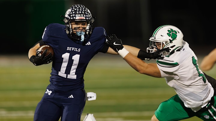 McDonald running back Casey Miller stiff arms Mogadore defensive back Maddox Smith during a Division VII regional final Nov. 21, 2025, in Macedonia, Ohio. McDonald running back Casey Miller stiff arms Mogadore defensive back Maddox Smith during a Division VII regional final Nov. 21, 2025, in Macedonia, Ohio.