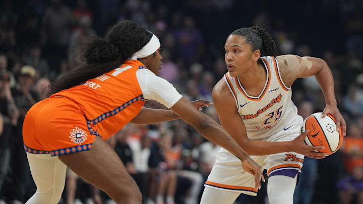 Aug 5, 2025; Phoenix, Arizona, USA; Phoenix Mercury forward Alyssa Thomas (25) shields the ball from Connecticut Sun forward Aneesah Morrow (24) in the first half at Footprint Center. Mandatory Credit: Rick Scuteri-Imagn Images