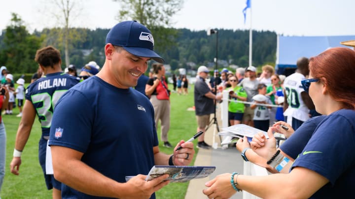 Jul 27, 2024; Renton, WA, USA; Seattle Seahawks head coach Mike Macdonald signs autographs after training camp at Virginia Mason Athletic Center. Mandatory Credit: Steven Bisig-USA TODAY Sports