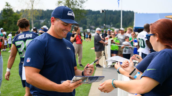 Jul 27, 2024; Renton, WA, USA; Seattle Seahawks head coach Mike Macdonald signs autographs after training camp at Virginia Mason Athletic Center. Mandatory Credit: Steven Bisig-USA TODAY Sports