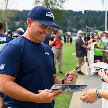 Jul 27, 2024; Renton, WA, USA; Seattle Seahawks head coach Mike Macdonald signs autographs after training camp at Virginia Mason Athletic Center. Mandatory Credit: Steven Bisig-Imagn Images