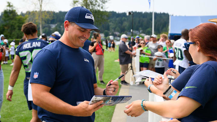 Jul 27, 2024; Renton, WA, USA; Seattle Seahawks head coach Mike Macdonald signs autographs after training camp at Virginia Mason Athletic Center. Mandatory Credit: Steven Bisig-Imagn Images