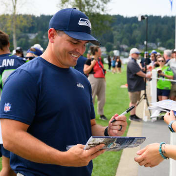 Jul 27, 2024; Renton, WA, USA; Seattle Seahawks head coach Mike Macdonald signs autographs after training camp at Virginia Mason Athletic Center. Mandatory Credit: Steven Bisig-USA TODAY Sports