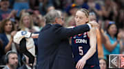 Connecticut Huskies head coach Geno Auriemma hugs guard Paige Bueckers.