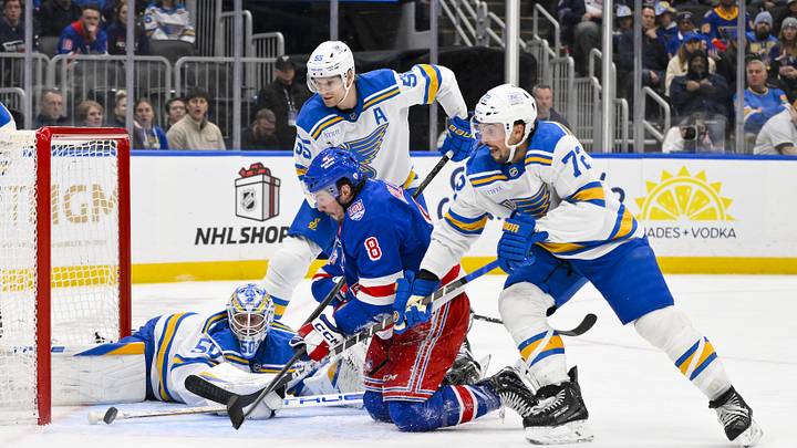 Dec 18, 2025; St. Louis, Missouri, USA; St. Louis Blues goaltender Jordan Binnington (50) defenseman Colton Parayko (55) and defenseman Justin Faulk (72) defends the net against New York Rangers left wing J.T. Miller (8) during the third period at Enterprise Center. Mandatory Credit: Jeff Curry-Imagn Images