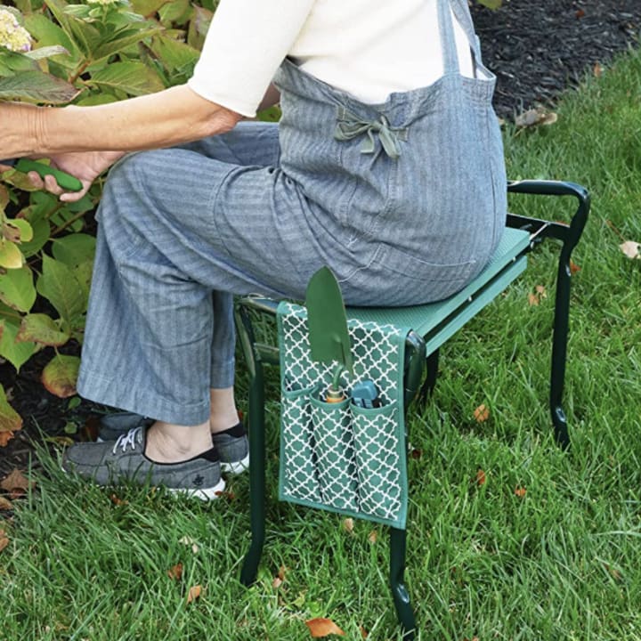 Person sitting on an Abco Tech garden lap and stool from Amazon tending to their garden.