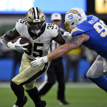 Aug 20, 2023; Inglewood, California, USA; New Orleans Saints running back Ellis Merriweather (35) runs with the ball against Los Angeles Chargers defensive tackle Scott Matlock (99) during the second half at SoFi Stadium. Mandatory Credit: Orlando Ramirez-USA TODAY Sports 