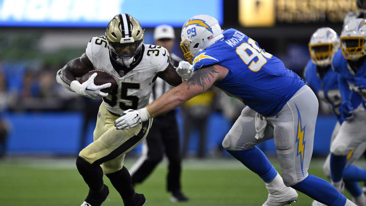 Aug 20, 2023; Inglewood, California, USA; New Orleans Saints running back Ellis Merriweather (35) runs with the ball against Los Angeles Chargers defensive tackle Scott Matlock (99) during the second half at SoFi Stadium. Mandatory Credit: Orlando Ramirez-USA TODAY Sports 