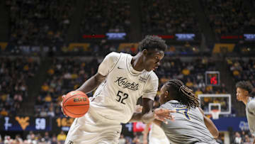 Mar 8, 2025; Morgantown, West Virginia, USA; UCF Knights center Moustapha Thiam (52) makes a move against West Virginia Mountaineers guard Javon Small (7) during the second half at WVU Coliseum. Mandatory Credit: Ben Queen-Imagn Images