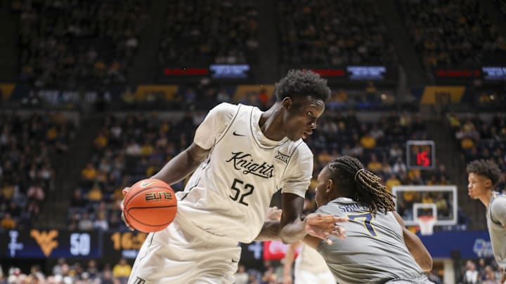 Mar 8, 2025; Morgantown, West Virginia, USA; UCF Knights center Moustapha Thiam (52) makes a move against West Virginia Mountaineers guard Javon Small (7) during the second half at WVU Coliseum. Mandatory Credit: Ben Queen-Imagn Images