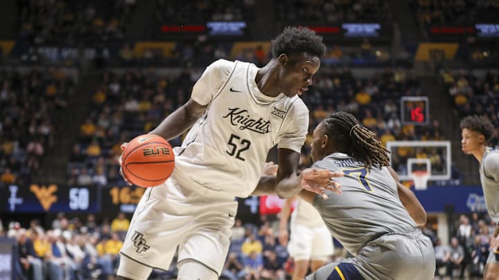 Mar 8, 2025; Morgantown, West Virginia, USA; UCF Knights center Moustapha Thiam (52) makes a move against West Virginia Mountaineers guard Javon Small (7) during the second half at WVU Coliseum. Mandatory Credit: Ben Queen-Imagn Images Mar 8, 2025; Morgantown, West Virginia, USA; UCF Knights center Moustapha Thiam (52) makes a move against West Virginia Mountaineers guard Javon Small (7) during the second half at WVU Coliseum. Mandatory Credit: Ben Queen-Imagn Images