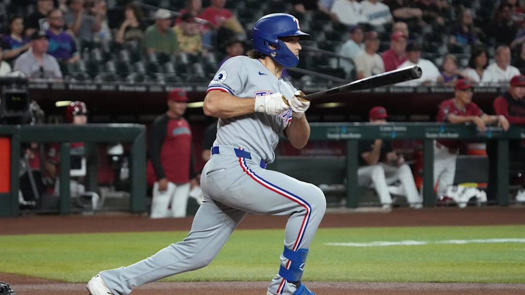 Sep 3, 2025; Phoenix, Arizona, USA; Texas Rangers shortstop Josh Smith (8) hits a single against the Arizona Diamondbacks in the first inning at Chase Field. Mandatory Credit: Rick Scuteri-Imagn Images