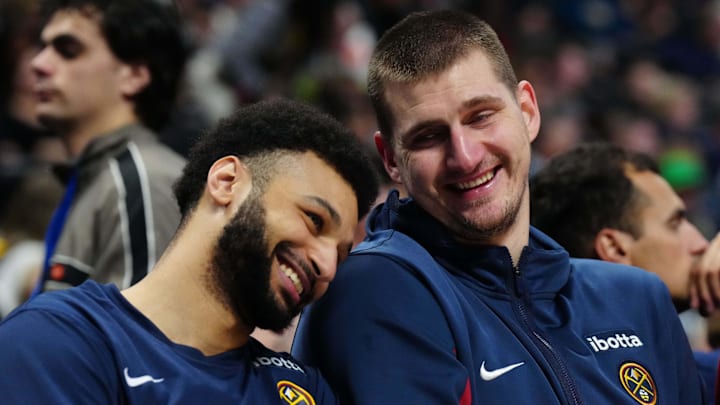 Dec 28, 2023; Denver, Colorado, USA; Denver Nuggets center Nikola Jokic (15) and guard Jamal Murray (27) react on the bench during the fourth quarter against the Memphis Grizzlies at Ball Arena. Mandatory Credit: Ron Chenoy-Imagn Images