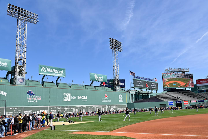 Fans line the field in front of the Green Monster before a game at Fenway Park. 