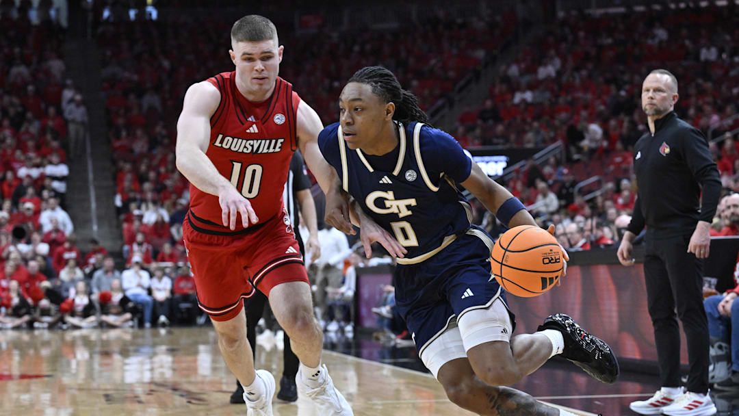 Feb 21, 2026; Louisville, Kentucky, USA;  Georgia Tech Yellow Jackets guard Akai Fleming (0) dribbles against Louisville Cardinals guard Isaac McKneely (10) during the first half at KFC Yum! Center. Mandatory Credit: Jamie Rhodes-Imagn Images