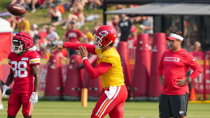 Jul 26, 2024; Kansas City, MO, USA; Kansas City Chiefs quarterback Patrick Mahomes (15) throws a pass as general manager Brett Veach watches in the background during training camp at Missouri Western State University. Mandatory Credit: Denny Medley-Imagn Images