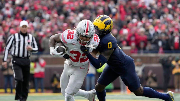 Nov. 25, 2023; Ann Arbor, Mi., USA;
Ohio State Buckeyes running back TreVeyon Henderson (32) is tackled by Michigan Wolverines defensive back Mike Sainristil (0) during the first half of Saturday's NCAA Division I football game at Michigan Stadium.
