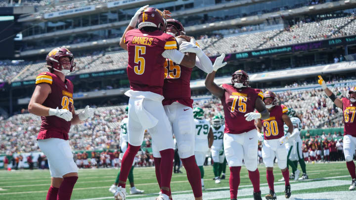 Commanders quarterback Jayden Daniels celebrates with teammates after scoring a touchdown during the first quarter against the New York Jets at MetLife Stadium.