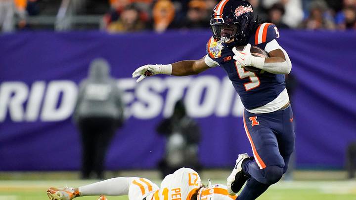 Illinois running back Ca'Lil Valentine (5) is grabbed by Tennessee linebacker Jadon Perlotte (27) in the fourth quarter of the Music City Bowl NCAA college football game on Dec. 30, 2025, in Nashville, Tennessee.