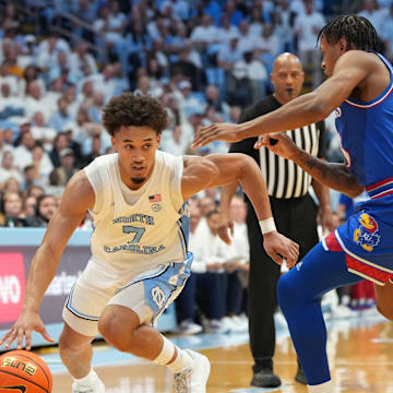 Nov 7, 2025; Chapel Hill, North Carolina, USA;  North Carolina Tar Heels guard Seth Trimble (7) with the ball as Kansas Jayhawks guard Elmarko Jackson (13) defends in the second half at Dean E. Smith Center. Mandatory Credit: Bob Donnan-Imagn Images