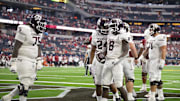 Sep 30, 2023; Arlington, Texas, USA; Texas A&M Aggies offensive lineman Kam Dewberry (75) and running back Earnest Crownover (24) and running back Le'Veon Moss (8) celebrate during the second half against the Arkansas Razorbacks at AT&T Stadium. Mandatory Credit: Jerome Miron-Imagn Images