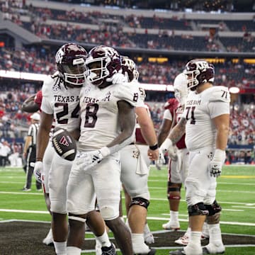 Sep 30, 2023; Arlington, Texas, USA; Texas A&M Aggies offensive lineman Kam Dewberry (75) and running back Earnest Crownover (24) and running back Le'Veon Moss (8) celebrate during the second half against the Arkansas Razorbacks at AT&T Stadium. Mandatory Credit: Jerome Miron-Imagn Images