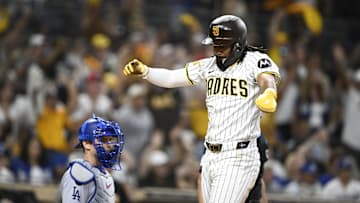 Aug 23, 2025; San Diego, California, USA; San Diego Padres right fielder Fernando Tatis Jr. (23) celebrates as he scores as Los Angeles Dodgers catcher Will Smith (16) looks on during the eighth inning at Petco Park. Mandatory Credit: Denis Poroy-Imagn Images