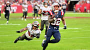 Nov 9, 2025; Tampa, Florida, USA; New England Patriots running back Treveyon Henderson (32) runs for a touchdown past Tampa Bay Buccaneers cornerback Josh Hayes (32) during the third quarter at Raymond James Stadium. Mandatory Credit: Jonathan Dyer-Imagn Images