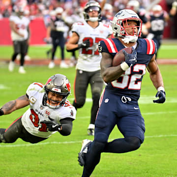 Nov 9, 2025; Tampa, Florida, USA; New England Patriots running back Treveyon Henderson (32) runs for a touchdown past Tampa Bay Buccaneers cornerback Josh Hayes (32) during the third quarter at Raymond James Stadium. Mandatory Credit: Jonathan Dyer-Imagn Images