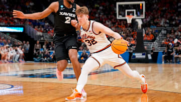 Illinois Fighting Illini guard Kasparas Jakucionis (32) drives against Xavier Musketeers forward Jerome Hunter (2) in the first half of the NCAA Tournament First Round game between the Illinois Fighting Illini and the Xavier Musketeers at Fiserv Forum in Milwaukee on Friday, March 21, 2025. Xavier was eliminated from the tournament, losing 86-73, to Illinois.