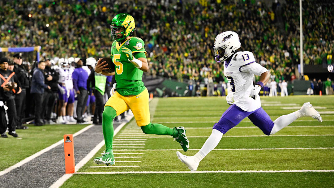 Dec 20, 2025; Eugene, OR, USA; Oregon Ducks quarterback Dante Moore (5) rushes for a touchdown as James Madison Dukes safety Tyler Brown (13) defends during the first quarter at Autzen Stadium.