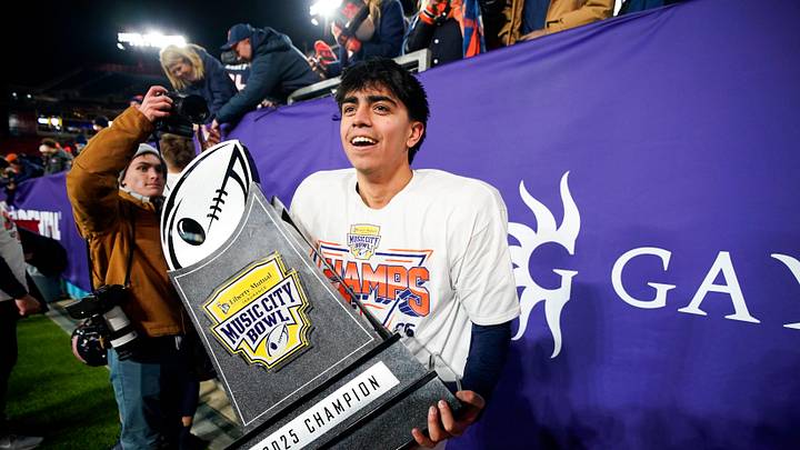 Illinois kicker David Olano (24) carries the Music City Bowl trophy after his field goal secured the win over Tennessee in an NCAA college football game on Dec. 30, 2025, in Nashville, Tennessee.