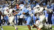 Nov 8, 2025; Chapel Hill, North Carolina, USA; North Carolina Tar Heels quarterback Gio Lopez (7) breaks a tackle as Stanford Cardinal linebacker Matt Rose (35) defends in the third quarter at Kenan Stadium. Mandatory Credit: Bob Donnan-Imagn Images