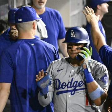 Los Angeles Dodgers shortstop Miguel Rojas (11), left, celebrates in the dugout after he scores against the Chicago White Sox during the seventh inning at Guaranteed Rate Field on June 24.
