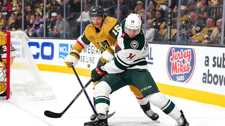 Minnesota Wild center Joel Eriksson Ek keeps the puck away from Vegas Golden Knights defenseman Noah Hanifin.