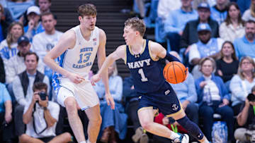 Nov 18, 2025; Chapel Hill, North Carolina, USA; Navy Midshipmen guard Austin Benigni (1) drives around North Carolina Tar Heels center Henri Veesaar (13) during the second half at Dean E. Smith Center. Mandatory Credit: Scott Kinser-Imagn Images