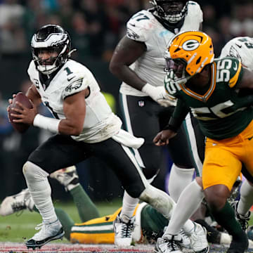 Philadelphia Eagles quarterback Jalen Hurts (1) scrambles against Green Bay Packers defensive end Kingsley Enagbare on Friday.