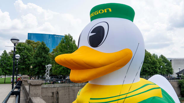 An inflatable of the University of Oregon Duck mascot floats on the White River in front of the NCAA Headquarters 