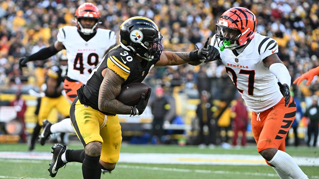 Nov 16, 2025; Pittsburgh, Pennsylvania, USA; Pittsburgh Steelers running back Jaylen Warren (30) runs with the ball against Cincinnati Bengals safety Jordan Battle (27) during the second half at Acrisure Stadium. Mandatory Credit: Barry Reeger-Imagn Images