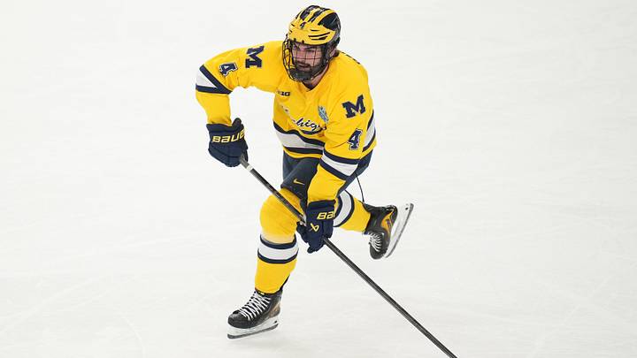 Apr 9, 2026; Las Vegas, Nevada, UNITED STATES; Michigan Wolverines defenseman Asher Barnett (4) moves the puck in the first period against the Denver Pioneers in the semifinals of the NCAA men's ice hockey Frozen Four at T-Mobile Arena. Mandatory Credit: Lucas Peltier-Imagn Images