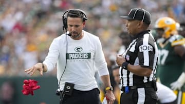 Sep 15, 2024; Green Bay, Wisconsin, USA;  Green Bay Packers head coach Matt LaFleur throws the challenge flag in front of Down Judge Patrick Holt (106) during the fourth quarter against the Indianapolis Colts at Lambeau Field. Mandatory Credit: Jeff Hanisch-Imagn Images
