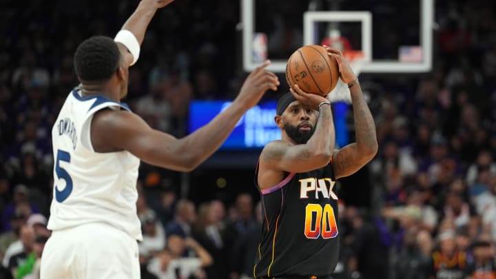 Apr 28, 2024; Phoenix, Arizona, USA; Phoenix Suns forward Royce O'Neale (00) shoots over Minnesota Timberwolves guard Anthony Edwards (5) during the first half of game four of the first round for the 2024 NBA playoffs at Footprint Center. Mandatory Credit: Joe Camporeale-USA TODAY Sports