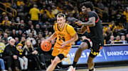 Dec 6, 2025; Iowa City, Iowa, USA; Iowa Hawkeyes guard Bennett Stirtz (14) goes to the basket as Maryland Terrapins forward Solomon Washington (9) defends during the second half at Carver-Hawkeye Arena. Mandatory Credit: Jeffrey Becker-Imagn Images