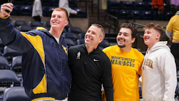 Nov 30, 2025; Morgantown, West Virginia, USA; West Virginia Mountaineers head coach Ross Hodge poses for a photo with students after defeating the Mercyhurst Lakers at Hope Coliseum. Mandatory Credit: Ben Queen-Imagn Images