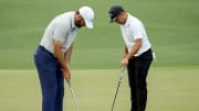 Scottie Scheffler and Xander Schauffele line up putts green during the first round of the 2024 Masters.