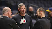 Feb 8, 2025; Morgantown, West Virginia, USA; Utah Utes assistant coach Josh Eilert talks with West Virginia University Athletic Director Wren Baker before their game at WVU Coliseum. Mandatory Credit: Ben Queen-Imagn Images
