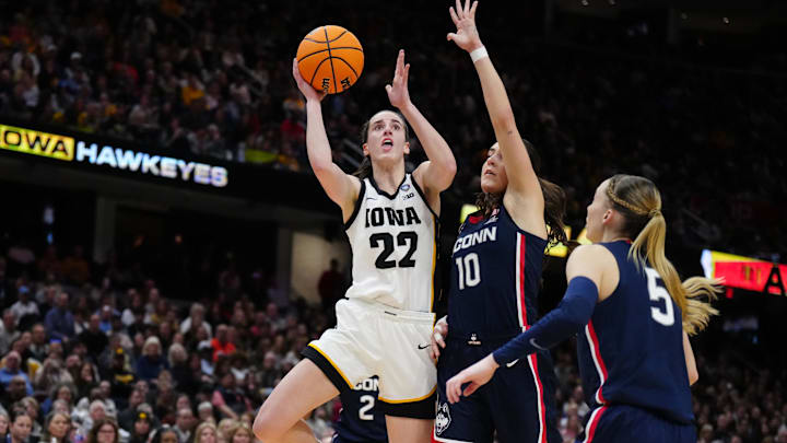 Apr 5, 2024; Cleveland, OH, USA; Iowa Hawkeyes guard Caitlin Clark (22) shoots against Connecticut Huskies guard Nika Muhl (10) and guard Paige Bueckers (5) in the second quarter in the semifinals of the Final Four of the womens 2024 NCAA Tournament at Rocket Mortgage FieldHouse. Mandatory Credit: Kirby Lee-Imagn Images