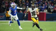 Jan 15, 2024; Orchard Park, New York, USA; Pittsburgh Steelers running back Jaylen Warren (30) runs the ball pressured by Buffalo Bills cornerback Taron Johnson (7) in the first half in a 2024 AFC wild card game at Highmark Stadium. Mandatory Credit: Kirby Lee-USA TODAY Sports